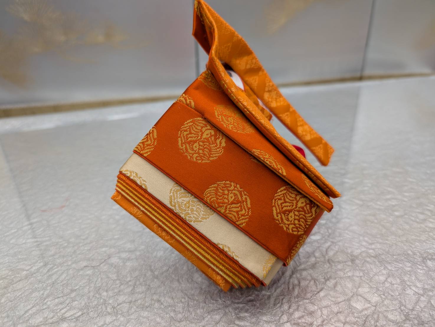 An example costume for the experience: orange silk with round crest patterns